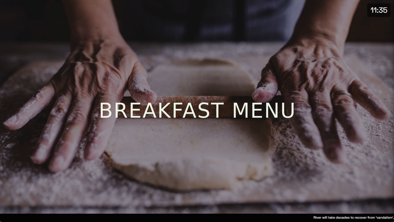 A live InfoSlides slideshow playing on a smart TV: a breakfast menu slide with a clock overlay in the top-right corner and a scrolling news ticker along the bottom